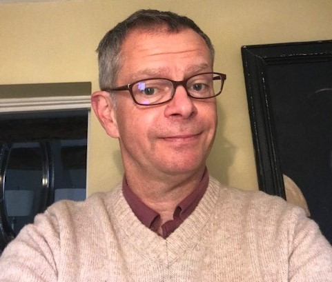 Paul Gossage wearing glasses smiling at the camera